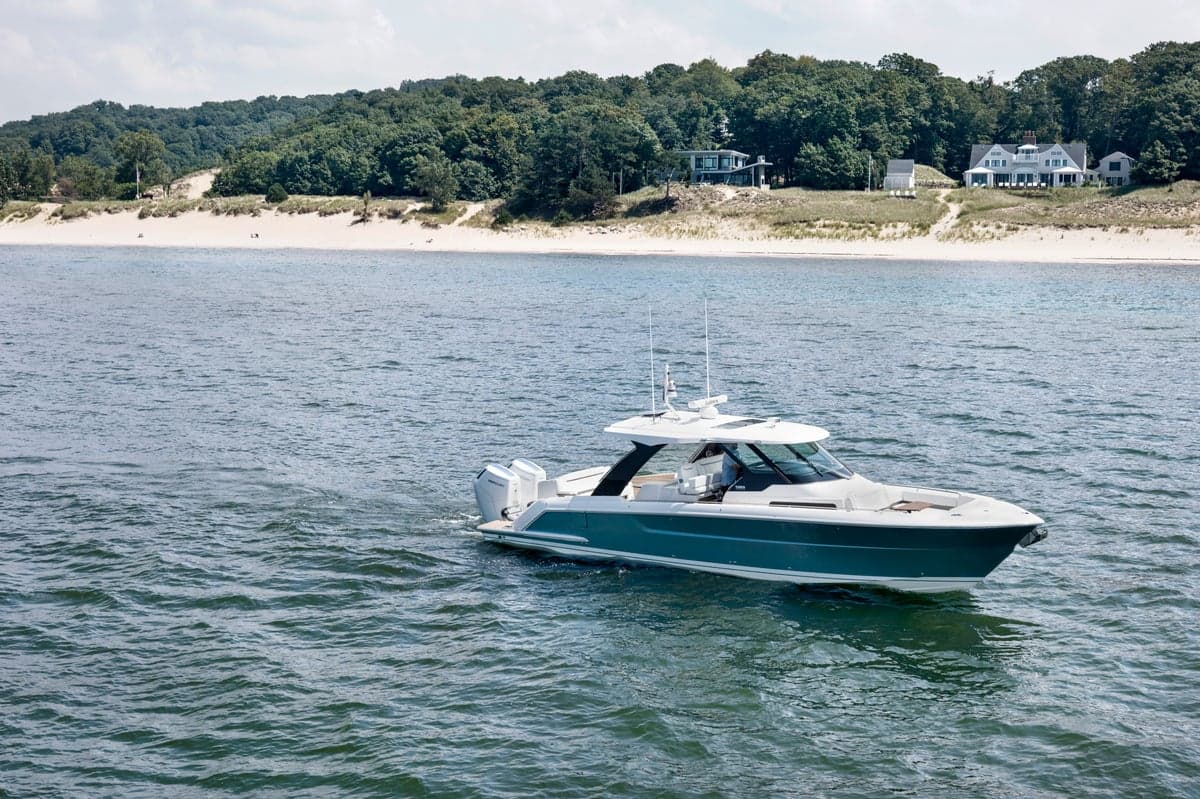 39 LS in Lake Michigan, sand dunes in background, Hull Color: Silver Lake, 39 foot boat